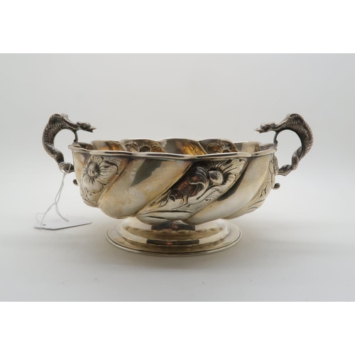 389 - A late Victorian twin handled bowl, the wrythen body with repousse floral decoration, the handles mo... 