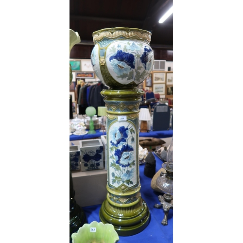 284 - A Burmantofts jardinière on stand, relief moulded and painted with blue poppies on a cream and green... 