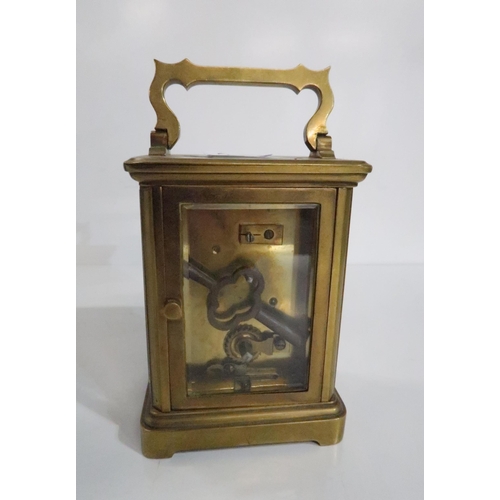 288 - A brass cased carriage clock and an oil lamp with Trademark in Lux Way to buttons