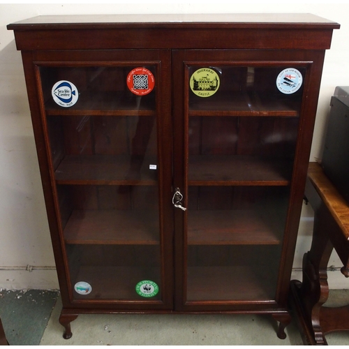 105 - A 20th century mahogany glazed two door bookcase on cabriole feet, 140cm high x 105cm wide x 30cm de... 