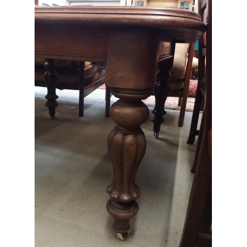 118 - A Victorian oak wind out dining table with turned supports