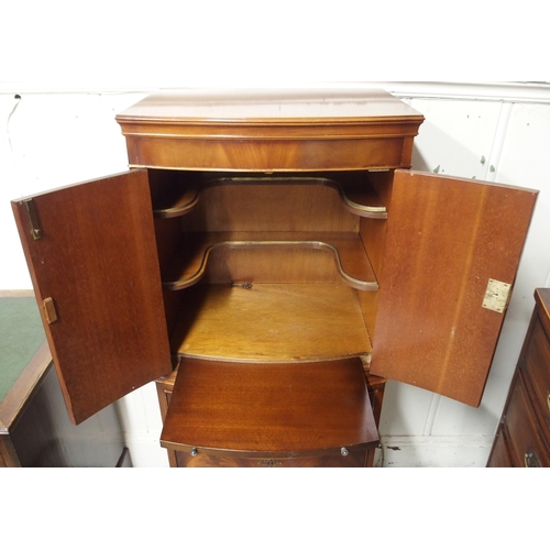 15 - A 20th century mahogany two door drinks cabinet on three drawer base, 132cm high x 57cm wide x 43cm ... 