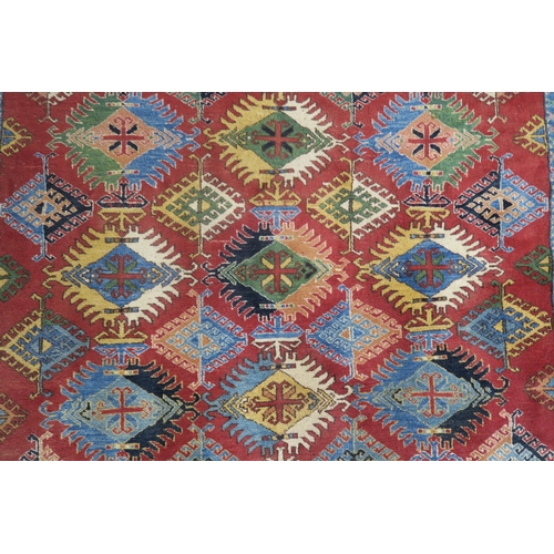 63 - A red ground Kazak rug with all over design and multicoloured borders, 210cm long x 188cm wide