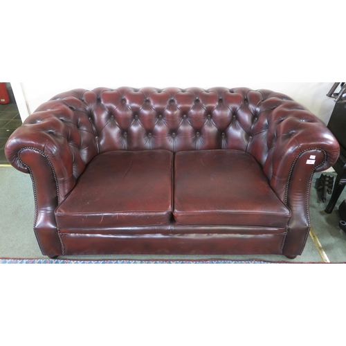 64 - A 20th century oxblood leather upholstered Chesterfield style two seater club sofa, 73cm high x 160c... 