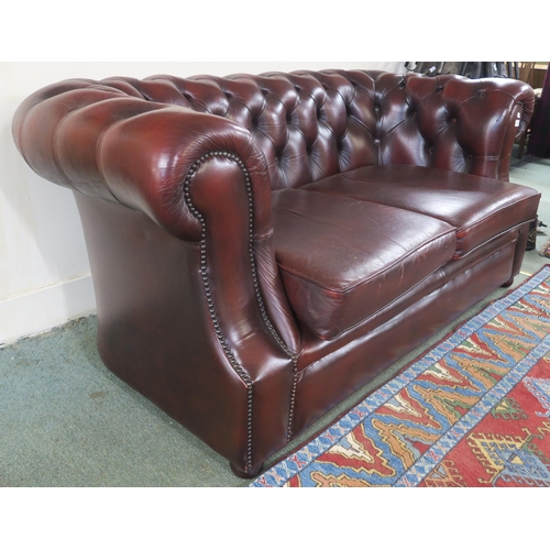 64 - A 20th century oxblood leather upholstered Chesterfield style two seater club sofa, 73cm high x 160c... 