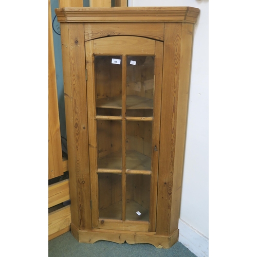 82 - A 20th century pine glazed corner cabinet and a pine hinged top stool (2)