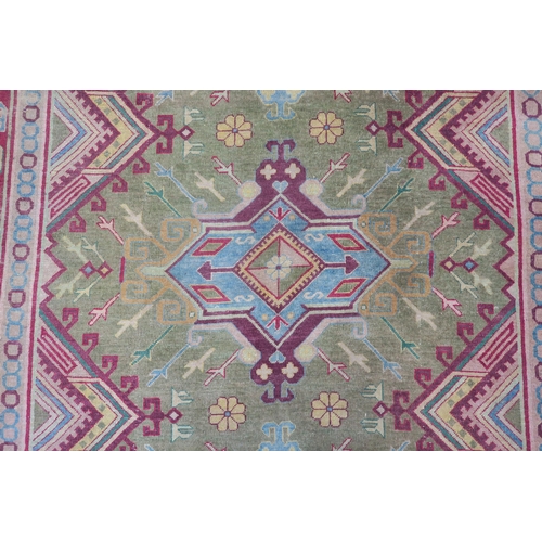 91 - A green ground Kilim rug with three geometric medallions and multicoloured borders, 271cm long x 187... 