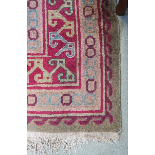 91 - A green ground Kilim rug with three geometric medallions and multicoloured borders, 271cm long x 187... 