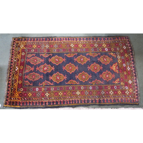 62 - A blue ground Iranian Turkman rug with all over lozenge design and multiple coloured borders, 180cm ... 