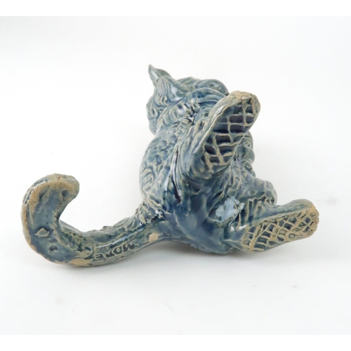 159 - A DUNMORE POTTERY MODEL OF A CATholding kittens, 11.5cm high