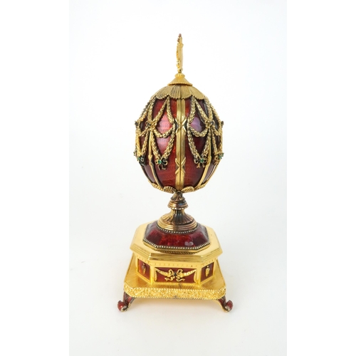 163 - A FRANKLIN MINT MUSICAL GOLD PLATED SILVER FABERGE IMPERIAL EAGLE EGGwith red guilloche enamel and b... 