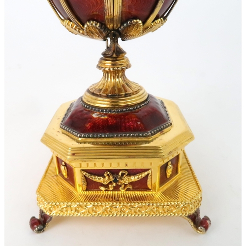 163 - A FRANKLIN MINT MUSICAL GOLD PLATED SILVER FABERGE IMPERIAL EAGLE EGGwith red guilloche enamel and b... 