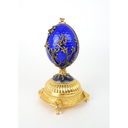 164 - A HOUSE OF IGOR CARL FABERGE MUSICAL SILVER GILT FIREBIRD EGGset with red gems and elements of lapis... 