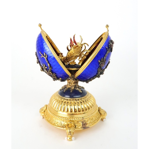 164 - A HOUSE OF IGOR CARL FABERGE MUSICAL SILVER GILT FIREBIRD EGGset with red gems and elements of lapis... 