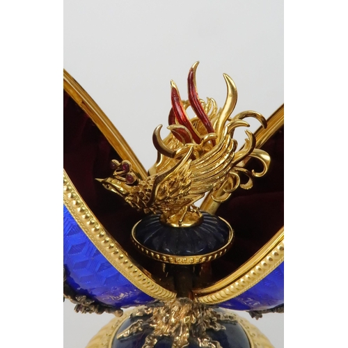 164 - A HOUSE OF IGOR CARL FABERGE MUSICAL SILVER GILT FIREBIRD EGGset with red gems and elements of lapis... 