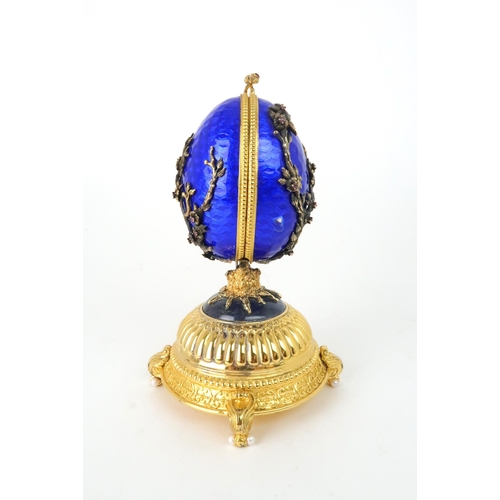 164 - A HOUSE OF IGOR CARL FABERGE MUSICAL SILVER GILT FIREBIRD EGGset with red gems and elements of lapis... 