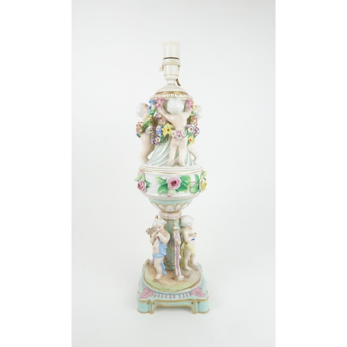 193 - A CONTINENTAL PORCELAIN URN SHAPED LAMPdecorated with putti with swags of flowers and applied roses,... 