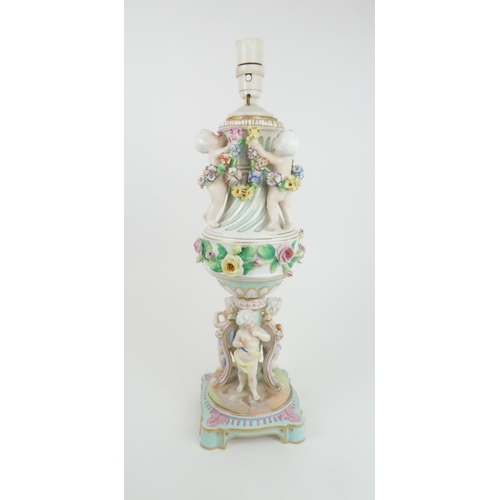 193 - A CONTINENTAL PORCELAIN URN SHAPED LAMPdecorated with putti with swags of flowers and applied roses,... 