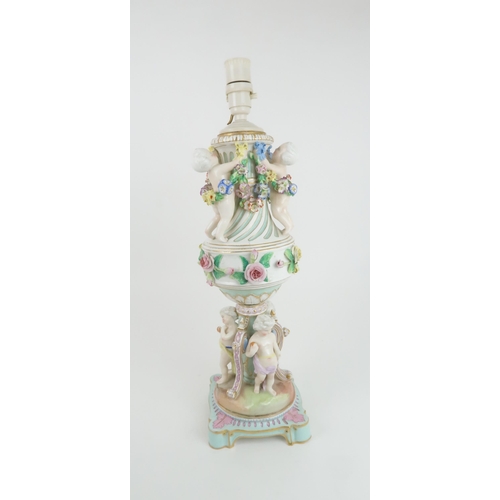 193 - A CONTINENTAL PORCELAIN URN SHAPED LAMPdecorated with putti with swags of flowers and applied roses,... 