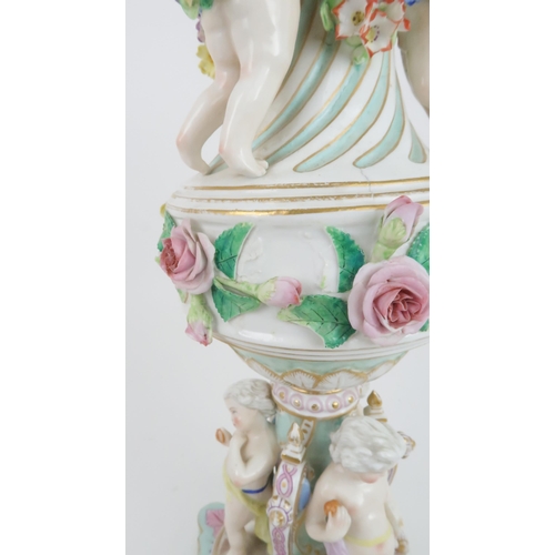 193 - A CONTINENTAL PORCELAIN URN SHAPED LAMPdecorated with putti with swags of flowers and applied roses,... 