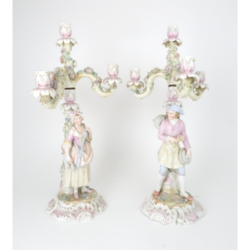 194 - A PAIR OF MEISSEN STYLE CANDELABRASeach with a figure below floral encrusted candle arms, 52cm high... 