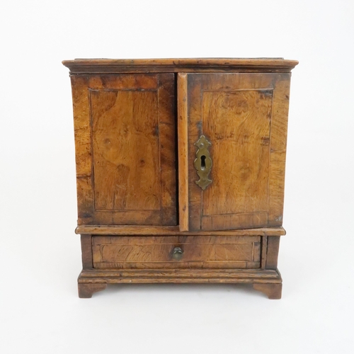 210 - AN APPRENTICE PIECE CHESTthe two door opening to reveal shelves above a drawer, 26cm high... 