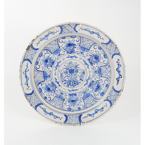 224 - AN 18TH CENTURY DELFT CHARGERdecorated with flowers and foliage, 35cm diameter... 