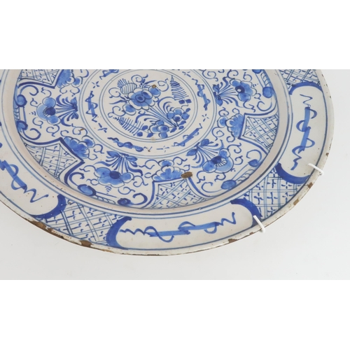 224 - AN 18TH CENTURY DELFT CHARGERdecorated with flowers and foliage, 35cm diameter... 