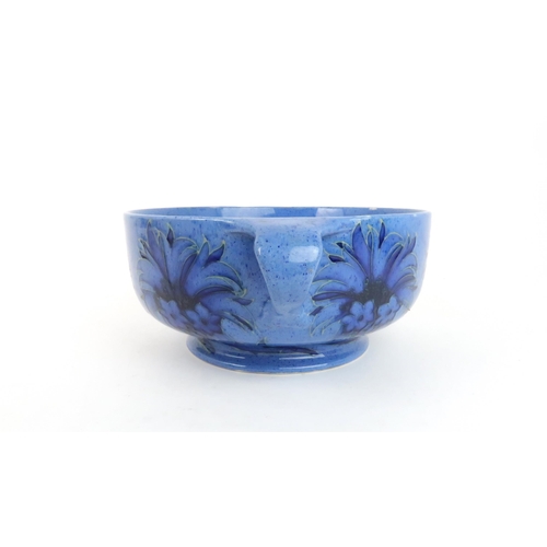 246 - WILLIAM MOORCROFT (1872-1945) TWO HANDLED BOWLdecorated in the Cornflower design on powder blue grou... 