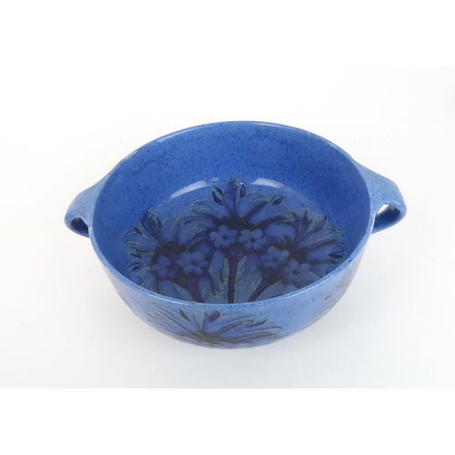 246 - WILLIAM MOORCROFT (1872-1945) TWO HANDLED BOWLdecorated in the Cornflower design on powder blue grou... 