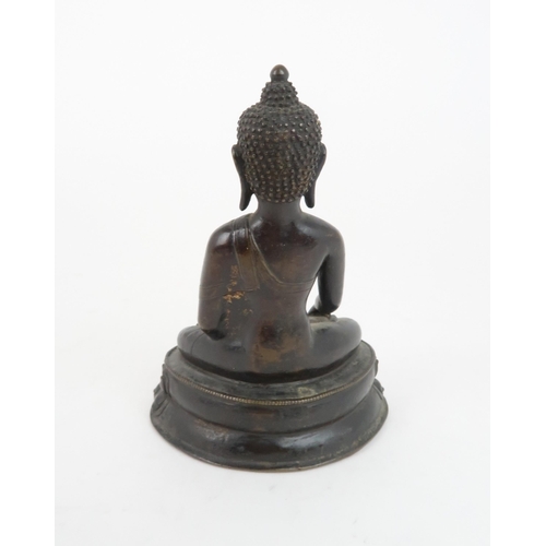 404 - A CHINESE BRONZE MODEL OF BUDDHAof traditional type and raised on a lotus throne, 13cm high... 