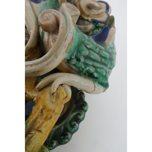 411 - A CHINESE SANCAI WALL VASEmodelled with a dragon, fish and cloud scrolls, 25cm high and a Chinese do... 