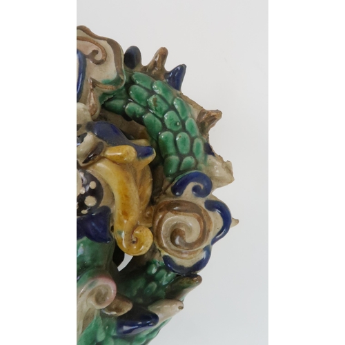 411 - A CHINESE SANCAI WALL VASEmodelled with a dragon, fish and cloud scrolls, 25cm high and a Chinese do... 