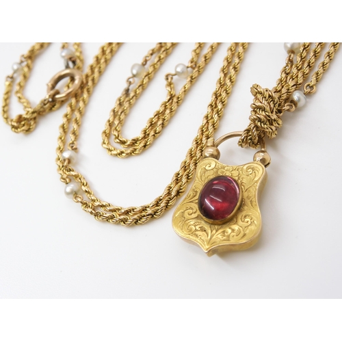 756 - A YELLOW METAL & PEARL GUARD CHAIN WITH GARNET CLASPthe bright yellow metal rope chain, is inter... 