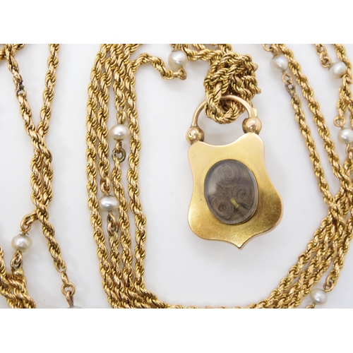 756 - A YELLOW METAL & PEARL GUARD CHAIN WITH GARNET CLASPthe bright yellow metal rope chain, is inter... 