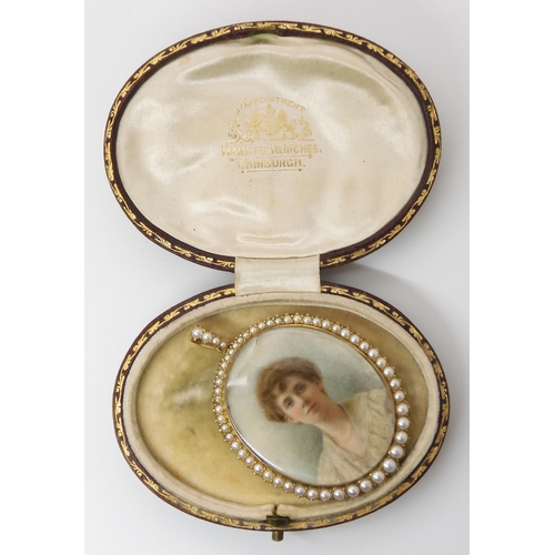 762 - A DOUBLE SIDED PORTRAIT MINIATURE LOCKETstamped 15ct to the bail, the portrait of a lady surrounded ... 