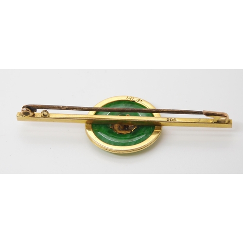 778 - A CHINESE GREEN HARDSTONE RONDEL BROOCHwith Chinese symbols mounted to the middle, the bar brooch is... 