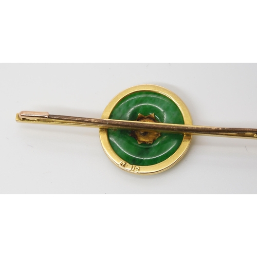 778 - A CHINESE GREEN HARDSTONE RONDEL BROOCHwith Chinese symbols mounted to the middle, the bar brooch is... 