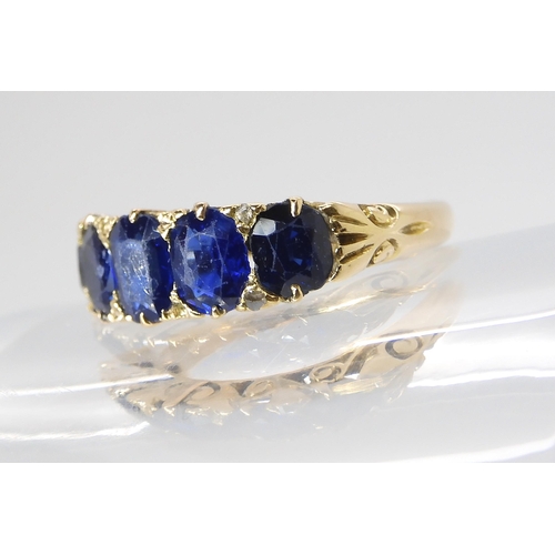 805 - A FIVE SAPPHIRE RINGin a classic yellow metal scrolled mount. Largest sapphire measures approx 5.99m... 