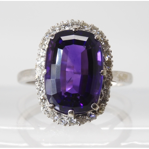 815 - AN 18CT AMETHYST AND DIAMOND CLUSTER RINGmade in 18ct white gold the fancy cushion cut amethyst is a... 