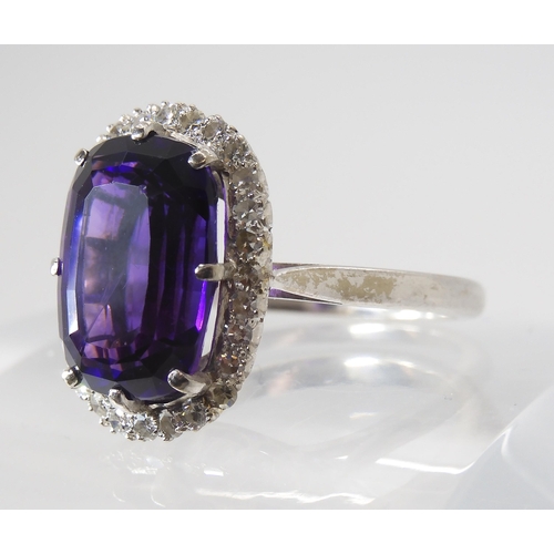 815 - AN 18CT AMETHYST AND DIAMOND CLUSTER RINGmade in 18ct white gold the fancy cushion cut amethyst is a... 