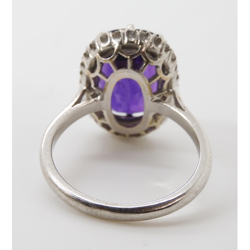 815 - AN 18CT AMETHYST AND DIAMOND CLUSTER RINGmade in 18ct white gold the fancy cushion cut amethyst is a... 