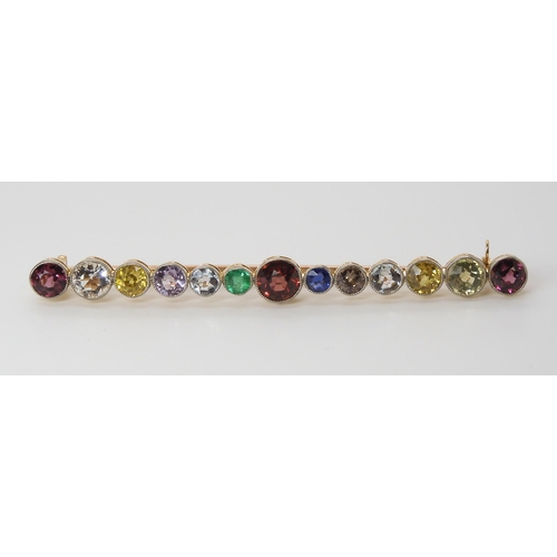 816 - A LARGE RAINBOW GEM SET BROOCH to include garnets, sapphire and emerald, set in yellow metal ga... 