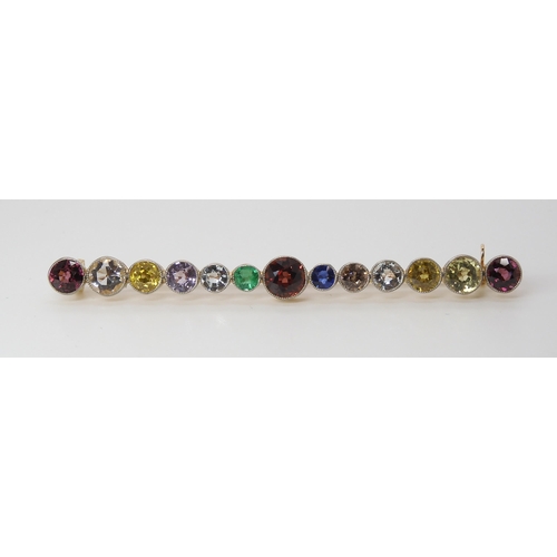 816 - A LARGE RAINBOW GEM SET BROOCH to include garnets, sapphire and emerald, set in yellow metal ga... 