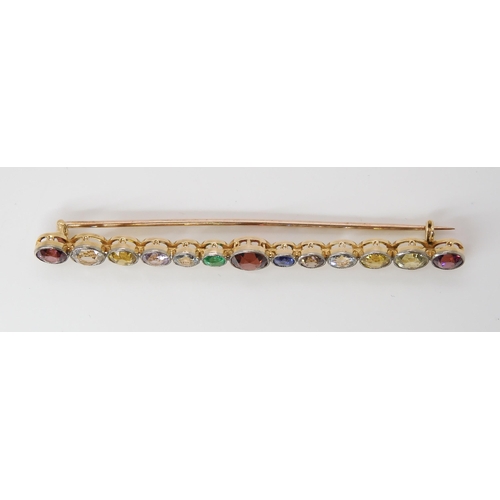 816 - A LARGE RAINBOW GEM SET BROOCH to include garnets, sapphire and emerald, set in yellow metal ga... 