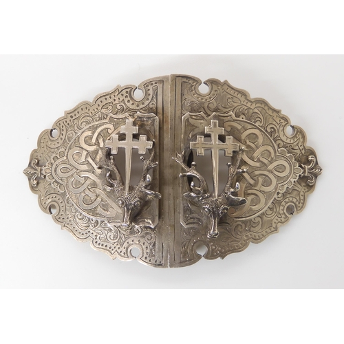 831 - A SILVER STAG'S HEAD BUCKLEwith all over knotwork and floral engraving, and applied fitchee crosses.... 