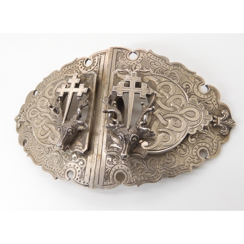 831 - A SILVER STAG'S HEAD BUCKLEwith all over knotwork and floral engraving, and applied fitchee crosses.... 