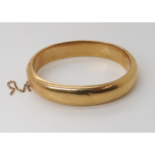 833 - A 15CT GOLD BANGLEof plain design, inner diameter 5.7cm x 4.9cm, width approx 1.2cm, weight 21.2gms... 