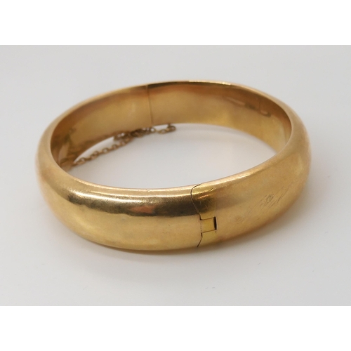 833 - A 15CT GOLD BANGLEof plain design, inner diameter 5.7cm x 4.9cm, width approx 1.2cm, weight 21.2gms... 