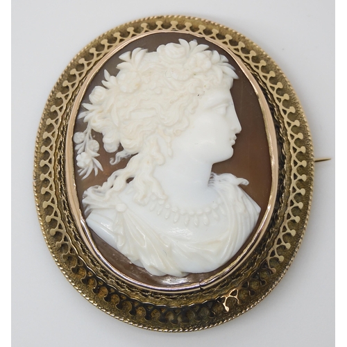 854 - A CLASSICAL THEMED CAMEO BROOCHfinely carved with a maiden with flowers in her hair. In a decorative... 